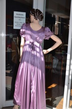 A shop model wearing the mauve satin dress from the cover of the book